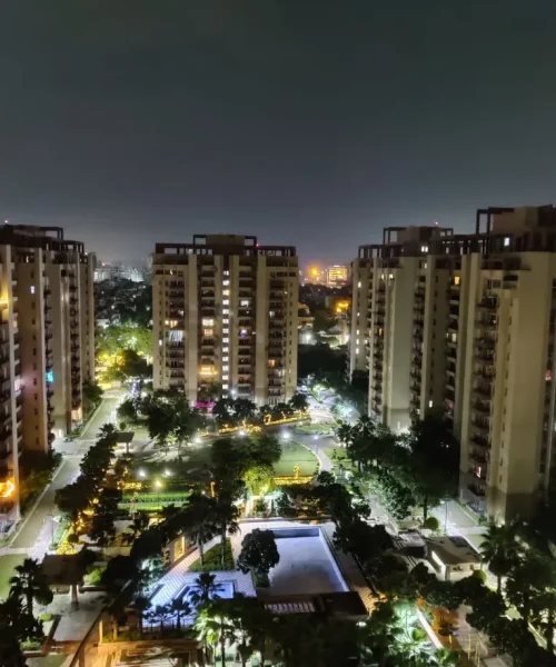 Bathed in warm golden lights, this vibrant residential complex offers a perfect blend of elegance and comfort. With lush landscaped gardens and a sparkling pool, it creates a serene haven for residents to unwind and enjoy city living at its finest.